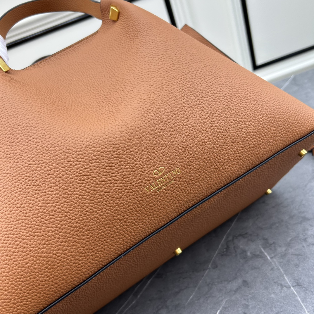 荔枝紋 Garavani VLOGO Escape 小牛皮小號購物袋，包袋兩側點綴紅色細節，金屬徽標飾件可用在包裝內部作為開合，亦可用在外部作為裝飾元素。
大號尺寸：41.*25*18cm