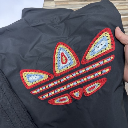 春秋季新款男士夾克外套女士外套夾克雙面穿外套紅色外套阿迪達斯三葉草外套三條槓夾克）
阿迪達斯 Adidas 三葉草兩面穿外套 
​黑紅撞色的外套在秋冬里超吸睛
​設計簡直是性價比王炸，雙面雙風格隨便切換，黑面走復古運動風，紅白條紋領撞色吸睛，側邊編織紋路藏滿細節

後背還有彩色刺繡三葉草，潮得毫不費力，紅面是經典白條紋款，簡約亮眼還巨顯白，
做工細節直接拿捏，全身細密鎖邊走線，針腳勻得找不出一根歪線，側邊編織紋路是規整手工走線，穿再久都不會松垮開線，

五金輔料更是誠意滿滿，領口織帶包边厚实挺