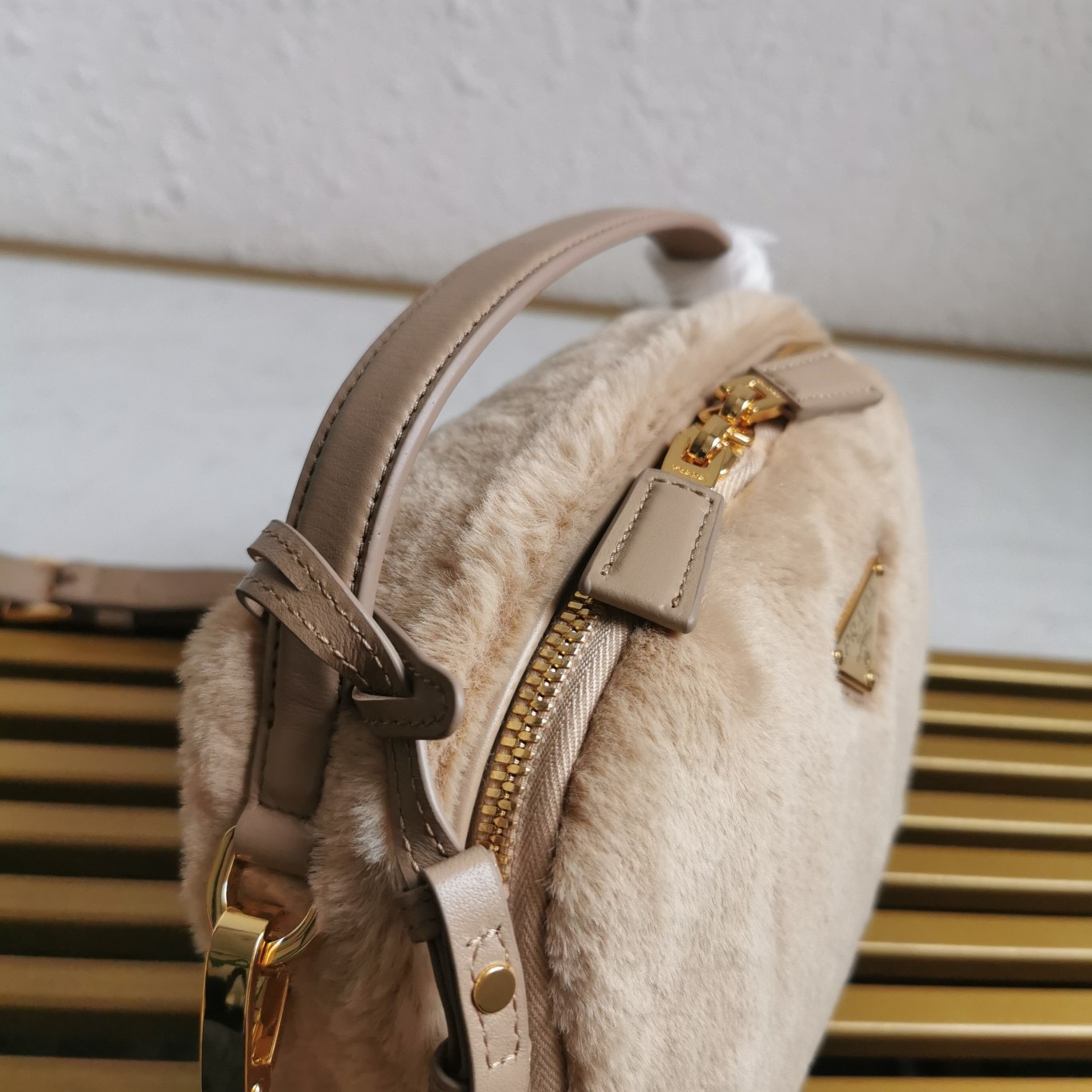 【 原單】🎉最新款迷你手袋🎉1BH208羊毛🎉🎉這款迷你手袋結構挺括，風格百搭，搭配柔軟的羊毛皮，彰顯冬日魅力。皮革細節與雙向拉鍊開合和金屬五金配件錦上添花，飾有塗琺瑯三角形金屬徽標。內配進口小羊皮，上身效果非常酷/時尚，冬天必備爆款🎉寶寶們，趕緊入手吧
尺寸：長19.5x高13x底6cm