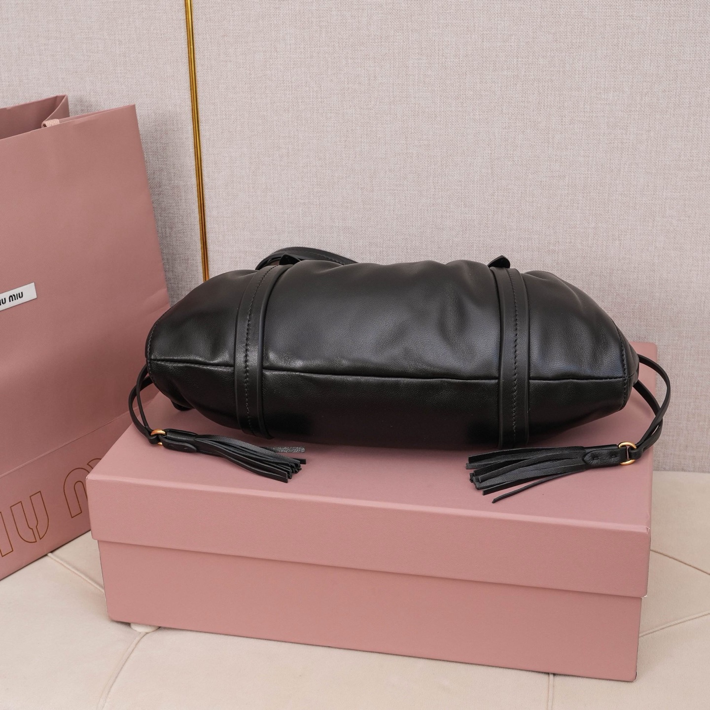 MIU中古腋下饺子包，全新植柔羊皮满满复古怀旧风情，搭配钢质做旧金属五金配件，质感高级典雅，袋口采用抽绳束口设计，细密的皱褶花边立体而俏皮，高级又不失慵懒随性，内搭全新条纹帆布里，配一个拉链隔层，独特的设计谁用谁好看