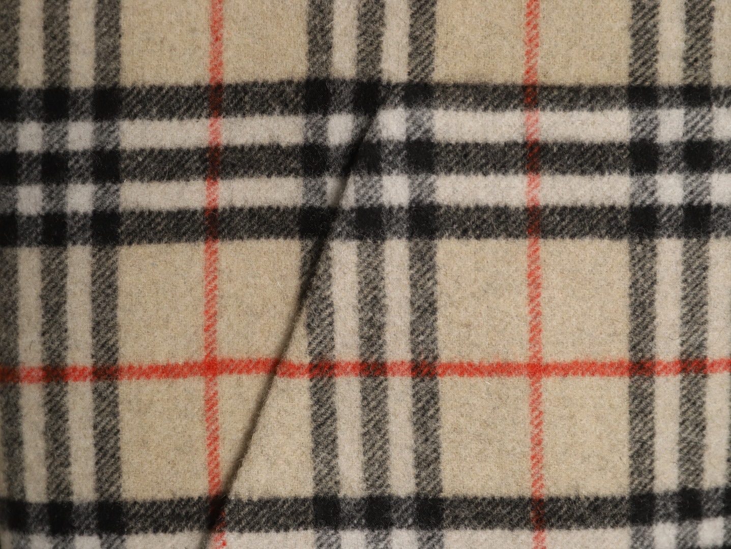 🔝BURBERRY巴寶莉BBR 雙面穿羊毛連帽外套
精選雙面羊毛斜紋面料，通過獨特的拉絨工藝處理，使表層呈現細膩豐盈的絨毛質感，觸感如雲朵般柔軟親膚，同時保留羊毛天然的保暖性與透氣性。一面以沈穩黑色演繹低調奢華，另一面則鋪滿標誌性的紅、黑、駝三色交織的經典圖案，既是品牌視覺符號，也為穿搭注入復古氣息。雙面可穿的設計，讓一件外套擁有兩種風格。
選用優質羊絨纖維進行精細紡紗，確保紗線的均勻性和強度。然後，通過先進的織造技術將紗線織成具有雙面效果的毛呢面料。
面料在裁剪前會經過預縮處理