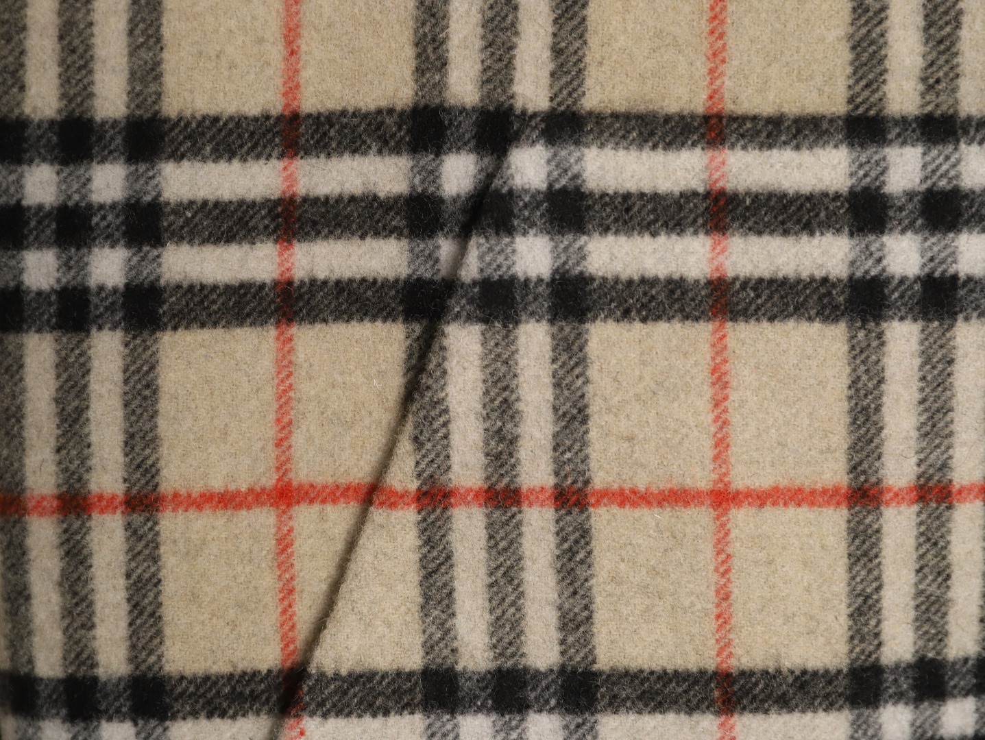 🔝BURBERRY巴寶莉BBR 雙面穿羊毛連帽外套
精選雙面羊毛斜紋面料，通過獨特的拉絨工藝處理，使表層呈現細膩豐盈的絨毛質感，觸感如雲朵般柔軟親膚，同時保留羊毛天然的保暖性與透氣性。一面以沈穩黑色演繹低調奢華，另一面則鋪滿標誌性的紅、黑、駝三色交織的經典圖案，既是品牌視覺符號，也為穿搭注入復古氣息。雙面可穿的設計，讓一件外套擁有兩種風格。
選用優質羊絨纖維進行精細紡紗，確保紗線的均勻性和強度。然後，通過先進的織造技術將紗線織成具有雙面效果的毛呢面料。
面料在裁剪前會經過預縮處理