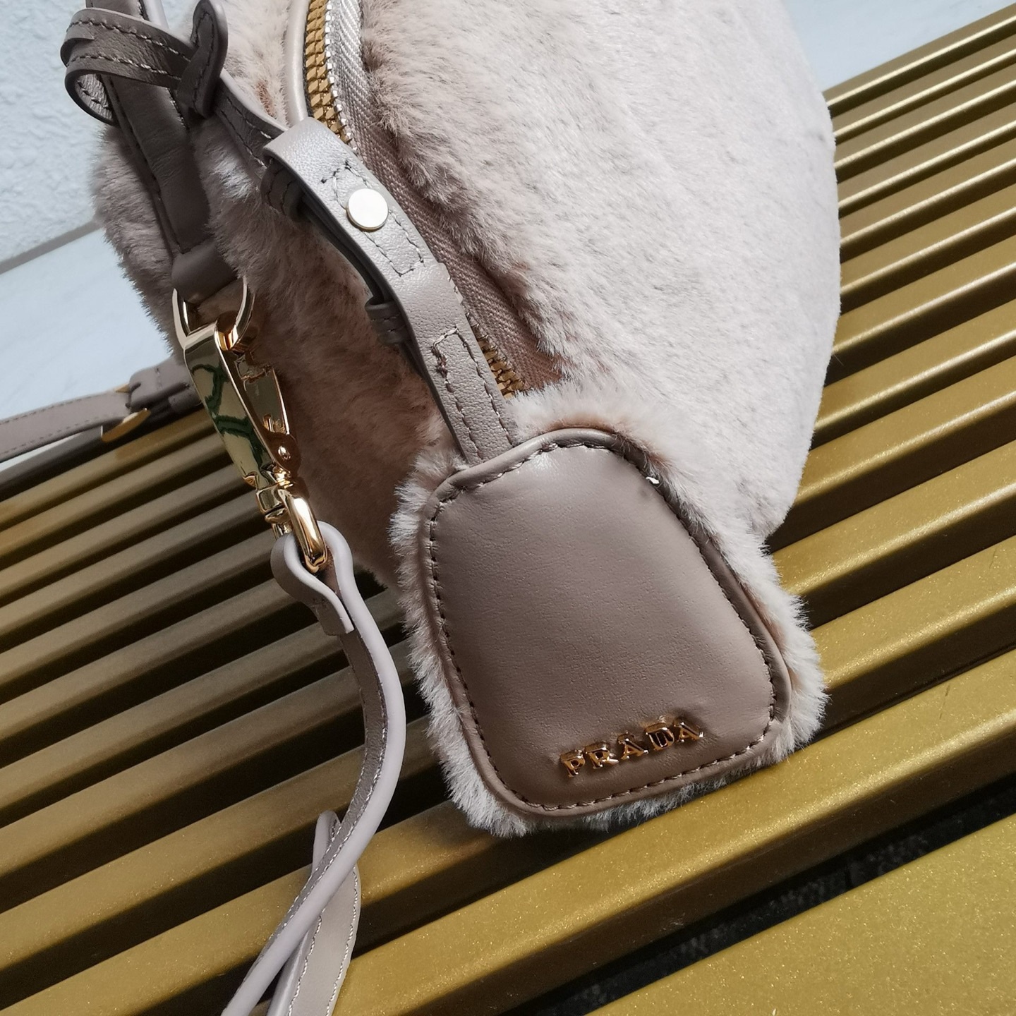 【 原單】🎉最新款迷你手袋🎉1BH208羊毛🎉🎉這款迷你手袋結構挺括，風格百搭，搭配柔軟的羊毛皮，彰顯冬日魅力。皮革細節與雙向拉鍊開合和金屬五金配件錦上添花，飾有塗琺瑯三角形金屬徽標。內配進口小羊皮，上身效果非常酷/時尚，冬天必備爆款🎉寶寶們，趕緊入手吧
尺寸：長19.5x高13x底6cm