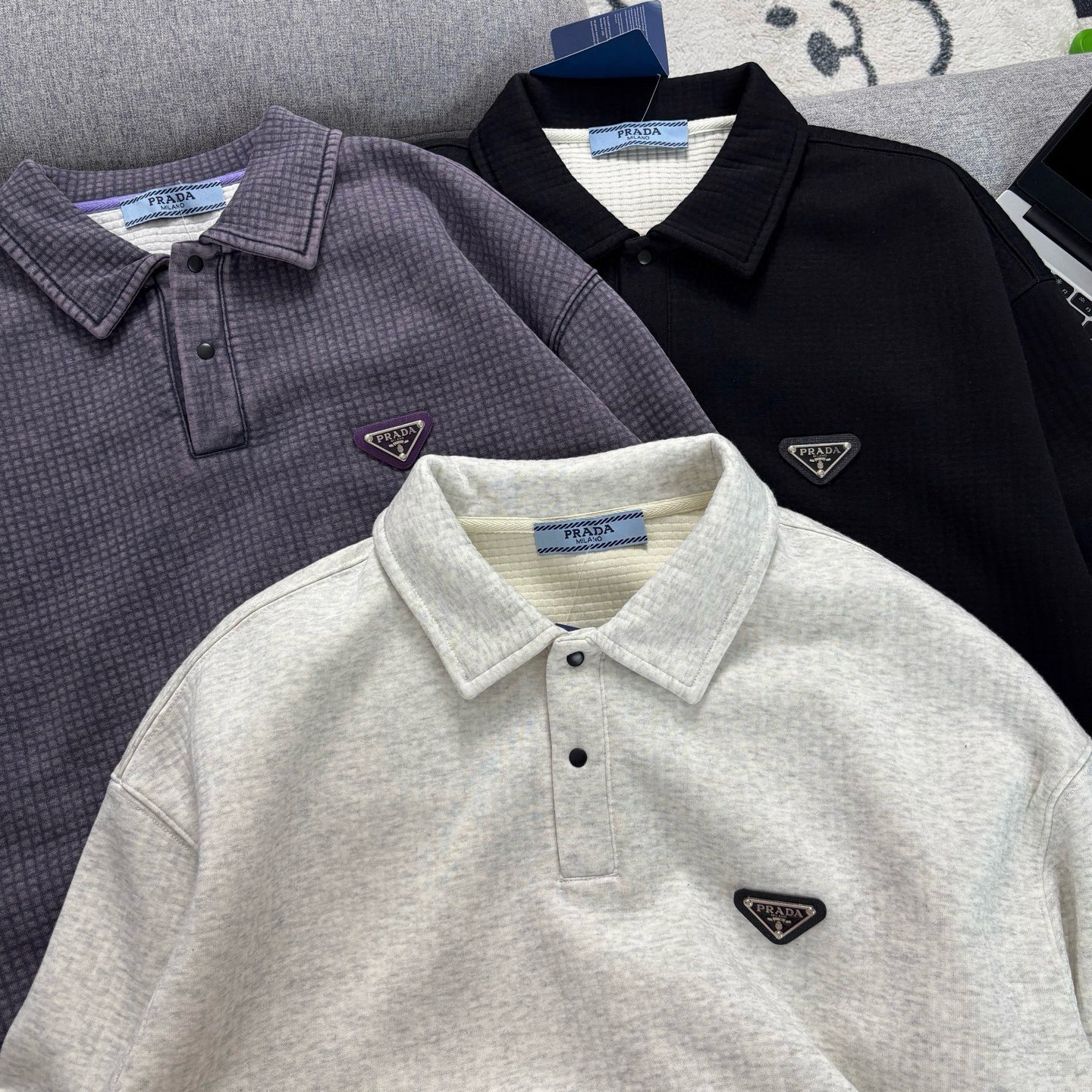 Prada普拉達日系翻領長袖衛衣
原相機📷實拍 質感看得見
水洗做舊工藝，質地軟軟糯糯有質感
版型寬松 遮肉顯瘦 不挑身材
斜紋肌理感泡泡TR優質面料
紋路清晰自然 觸感軟糯舒適 
男女皆可穿可當情侶裝！
質量放心入手不亂吹品質值得信賴

顏色：花灰  黑色  紫灰色
尺碼：M-2XL

尺碼    M     L     XL    XXL   
衣長    69    71    73     75   
胸圍    116  120   124  128
袖長    55    56