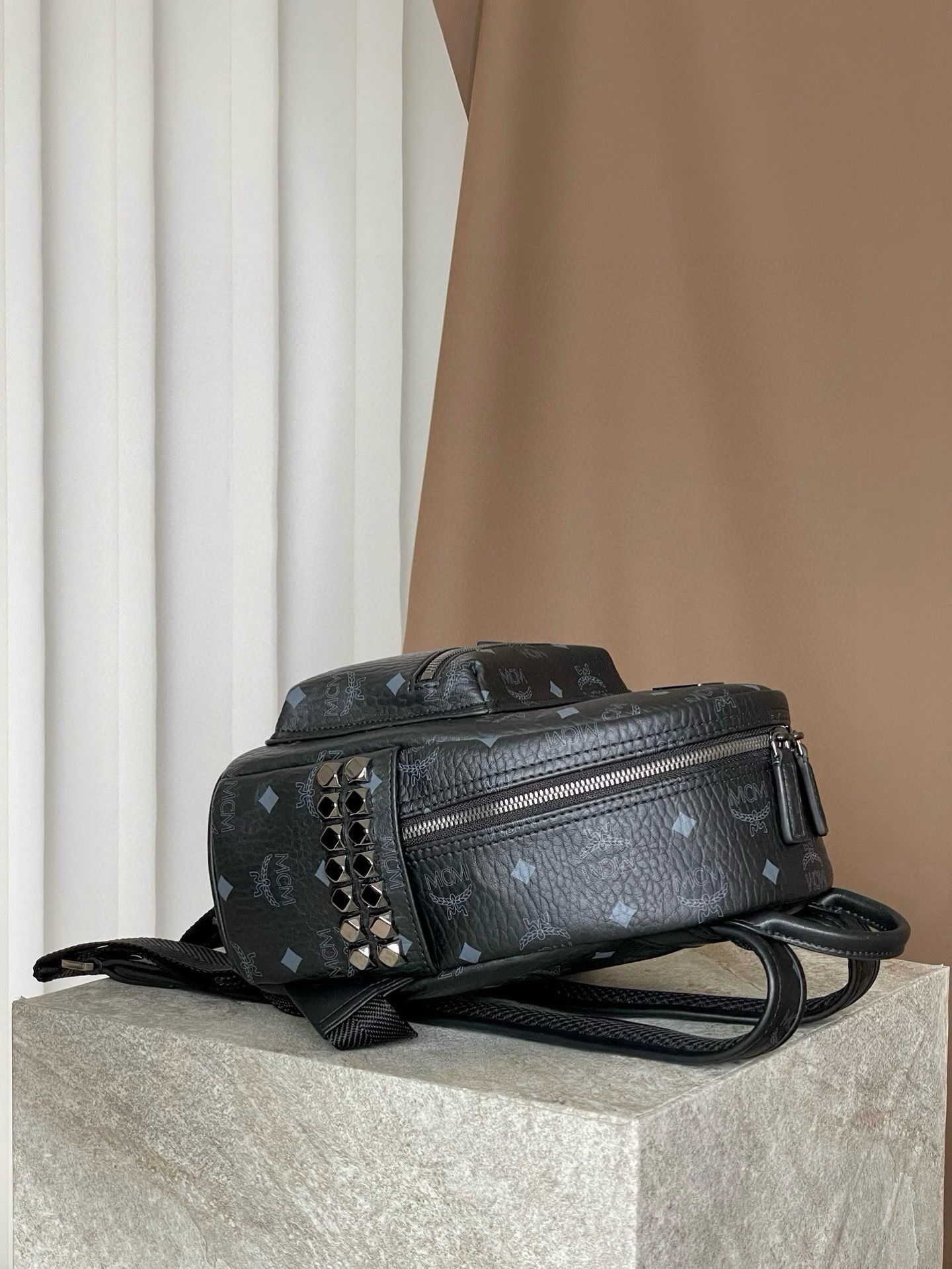 𝐌𝐂𝐌 𝐒𝐭𝐚𝐫𝐤 𝐕𝐢𝐬𝐞𝐭𝐨𝐬，𝐌𝐢𝐧𝐢 铆钉双肩背包黑色这款迷你 Stark 双肩背包是一款可以彰显独特风格的小配饰。MCM 经典款的缩小版本采用我们标志性的 Visetos 涂层帆布制成，配以奢华的人造皮革衬里和铆钉饰边