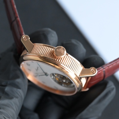 224年前，阿伯拉罕-路易·宝玑先生在他所创立的巴黎钟表堤岸制表工坊中，创造了制表史上令无数人赞叹的陀飞轮调速装置。这一无比复杂的精密机构彰显了宝玑先生卓然超群的远见与创想，时至今日仍对高级制表业有着重要意义。至今，陀飞轮的作用和意义已不仅是提高走时的精准度，而是谱写了制表领域的辉煌篇章。宝玑陀飞轮时计臻品在百年征程中不断创新，超越自我，集精湛机械制造技艺与深厚美学原理于一身，创制出演绎复杂迷人的机械世界。腕表的表冠上刻有著名的宝玑品牌标志，从侧面我们可以看到表王宝玑著名的钱币纹饰，代表着温文尔雅