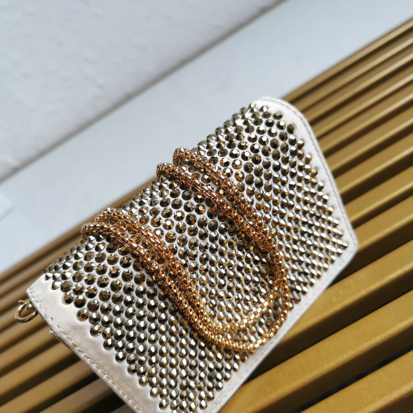 【 原單】🎉2023新款金色系項鍊水晶小包🎉1MR024🎉🎉這款Duchesse面料卡片夾通體飾以仿水晶，於表面營造出光影格調和虹彩炫色，彰顯華美且不失功能性的設計。最愛是這條可拆卸可調節鐵璉肩帶，又可當腰包裝飾😍😍又可當搭配衣服項鍊裝飾，中間三角形標可調節活動，賦予單品多樣的佩戴方式。空間可裝口紅💄/耳機/鑰匙🚗....夜燈下bling bling,太美了。值得入手🎉🎉尺寸：長11.5cm*高8cm