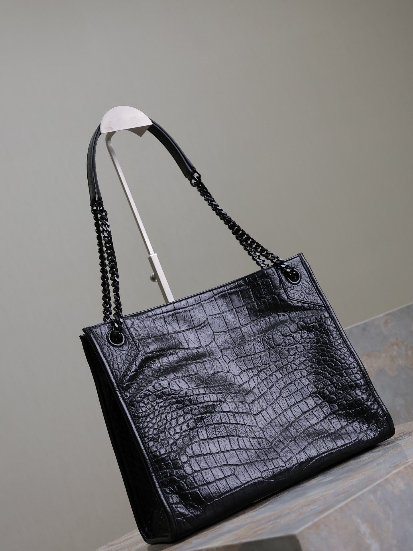 黑色黑扣鰐魚紋·
Niki shopping bag_
意大利進口鰐魚壓紋牛皮，五金是全牛皮包裹，工藝十分精湛！包袋中間有磁吸扣，保障了包包使用的安全性；內里有一拉鍊隔層及敞口插槽設計可放手機及零錢卡片，方便拿取，不會出現因為是大包而出現找不到東西的情況；包包自重非常輕，容量又足夠大，公文包、旅行包、購物袋、媽媽包隨意切換，實用性爆表！
型號：577999
尺寸：33x27x11.5cm