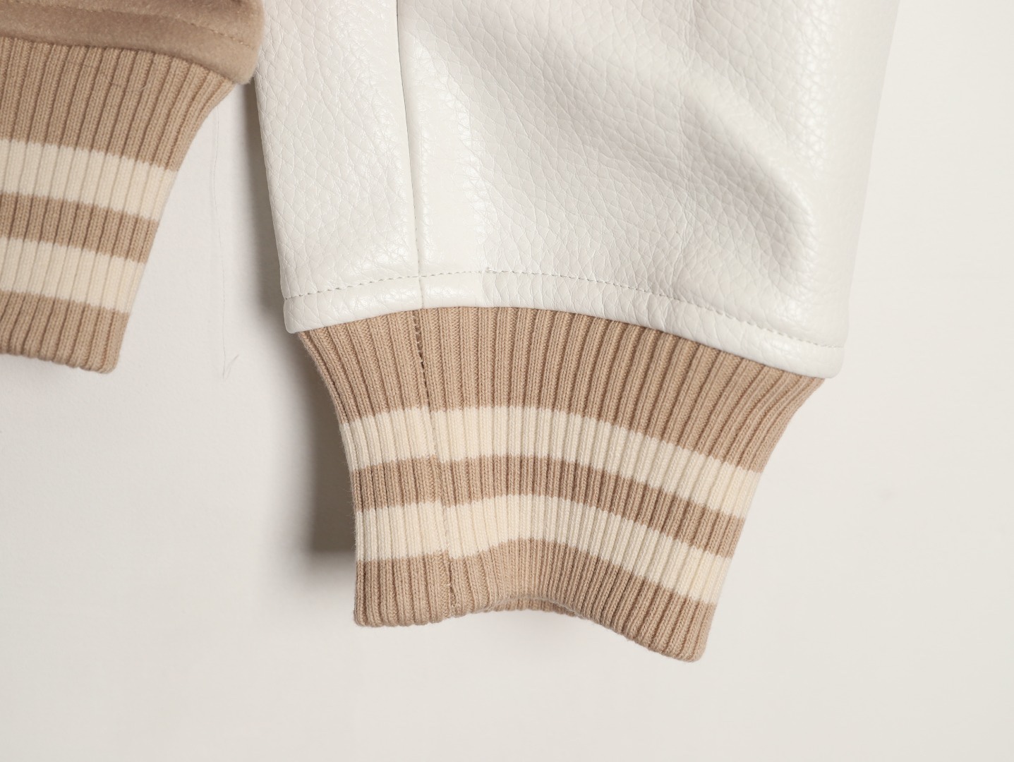 Louis Vuitton/路易威登 26ss 動物樂園刺繡棒球服外套
材質拼接：衣身採用淺卡其色羊毛混紡面料，柔軟且有挺括感；袖子為奶白色荔枝紋牛皮，質感細膩，淺色系搭配更顯清爽。

• 裝飾亮點：衣身滿印精緻動物刺繡（長頸鹿、斑馬、大象、黑豹等）與棕櫚樹圖案，左胸綴有“L.V.M.”字母標識，充滿童趣與度假感，辨識度極高。

• 版型結構：經典棒球服版型，羅紋條紋領口/袖口/下擺，防風收型；正面按扣開合，兩側配白色撞色插袋，兼顧實用性與設計感。
N SIZE:S-XL
