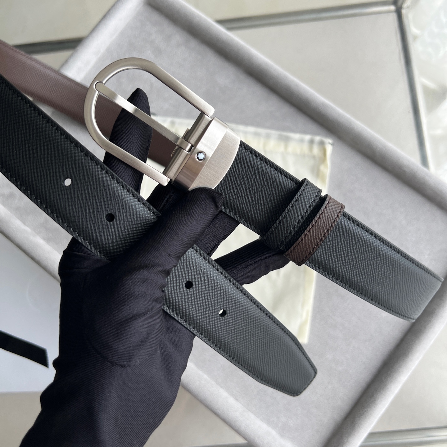 馬蹄形帶扣黑色/棕色雙面皮帶（35毫米）
馬蹄形閃亮鍍釕帶扣。可調節長度，3.5cm黑色和棕色雙面皮帶。打造經典靈動造型。
貨號 錶帶描述 黑色和棕色雙面牛皮皮帶 皮革圖案 金屬圓環上飾有萬寶龍六角白星 標識 搭扣裝置 易開啓裝置，可調節皮帶長度
搭扣形狀 馬蹄形主要顏色 黑色 | 棕色 搭扣類型 針扣式表扣