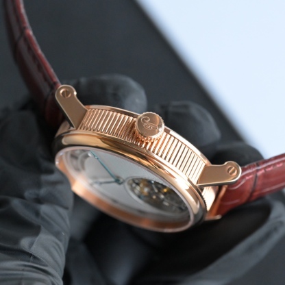 224年前，阿伯拉罕-路易·寶璣先生在他所創立的巴黎鐘錶堤岸制表工坊中，創造了制表史上令無數人贊嘆的陀飛輪調速裝置。這一無比複雜的精密機構彰顯了寶璣先生卓然超群的遠見與創想，時至今日仍對高級制表業有著重要意義。至今，陀飛輪的作用和意義已不僅是提高走時的精准度，而是譜寫了制表領域的輝煌篇章。寶璣陀飛輪時計臻品在百年徵程中不斷創新，超越自我，集精湛機械製造技藝與深厚美學原理於一身，創制出演繹複雜迷人的機械世界。腕表的表冠上刻有著名的寶璣品牌標誌，從側面我們可以看到表王寶璣著名的錢幣紋飾，代表著溫文爾雅