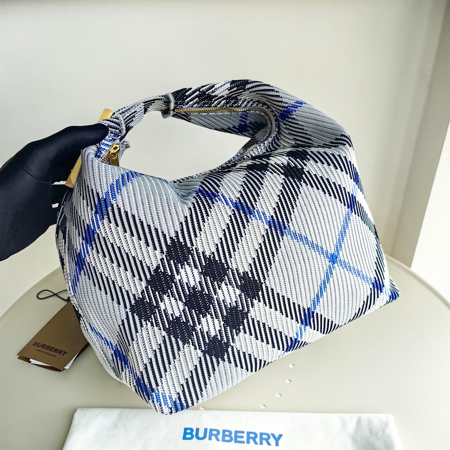 柔軟立挺包款，於意大利針織打造，裝飾 Burberry 格紋。質地輕盈，採用無內襯設計；衣夾造型掛扣鐫刻 Burberry 徽標，可輕鬆固定弧形頂部提柄。
– 拉鍊開合
– 拉絲金屬配件
– 衣夾掛扣鐫刻 Burberry 字母徽標
尺寸– 28 x 16.5 x 33.5cm