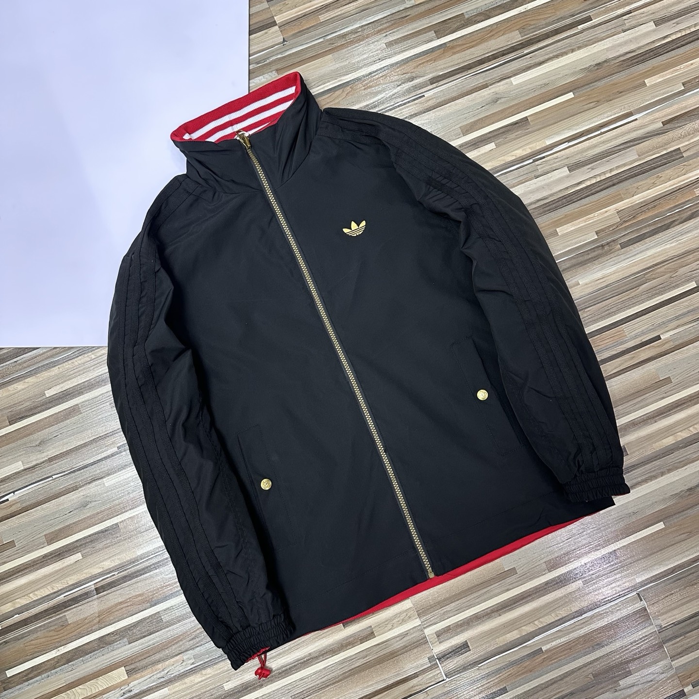 春秋季新款男士夾克外套女士外套夾克雙面穿外套紅色外套阿迪達斯三葉草外套三條槓夾克）
阿迪達斯 Adidas 三葉草兩面穿外套 
​黑紅撞色的外套在秋冬里超吸睛
​設計簡直是性價比王炸，雙面雙風格隨便切換，黑面走復古運動風，紅白條紋領撞色吸睛，側邊編織紋路藏滿細節

後背還有彩色刺繡三葉草，潮得毫不費力，紅面是經典白條紋款，簡約亮眼還巨顯白，
做工細節直接拿捏，全身細密鎖邊走線，針腳勻得找不出一根歪線，側邊編織紋路是規整手工走線，穿再久都不會松垮開線，

五金輔料更是誠意滿滿，領口織帶包边厚实挺
