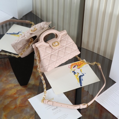 原廠級 粉色鏈條手袋
這款 Dior Jolie Top Handle 迷你鏈條手袋是二零二六早春成衣系列新品，呈現出優雅精緻的設計。採用黑色羊皮革精心製作，飾以藤格紋，翻蓋點綴以金色飾面金屬 CD 標誌和白色樹脂珠飾。內設一個隔層，可收納各種日常用品。搭配雙頂部手柄和可調節、可拆卸 CD 鏈條肩帶，肩帶由皮革帶和 CD 鏈環組成，飾以白色樹脂珠飾，可舒適手提、肩背或斜挎，可與日常或晚裝造型搭配。
