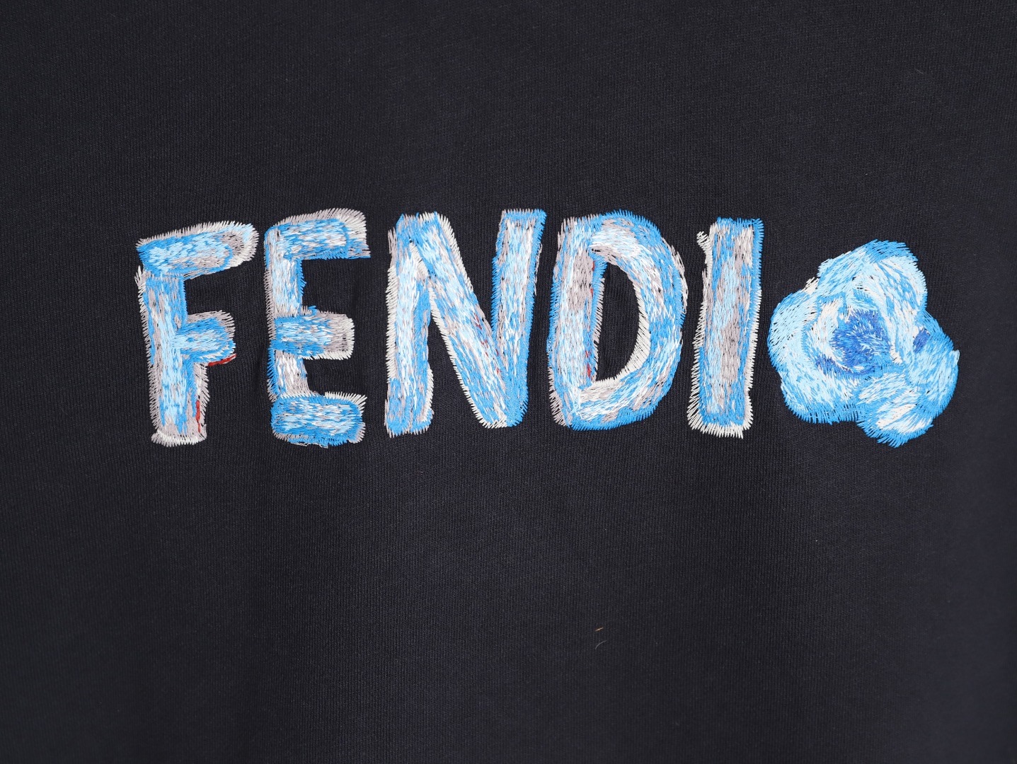 🔝FENDI芬迪FD 藍字母刺繡連帽衛衣
選用100%棉為基底編織而成的單面魚鱗布面料，正面為平滑的針織面，觸膚面通過針織機的浮線編織技術形成立體的毛圈，增加蓬松感， 同時觸感細膩。毛圈結構吸水量大且蒸發快，經過預縮處理之後，縮水率低於2%，確保成衣尺寸穩定。深藍色染整採用活性染料，色澤濃郁飽滿，多次洗滌不易褪色。
胸前“FENDI Flower”圖案採用日本田島繡花機精密刺繡，融合多色漸變與立體肌理，呈現獨特的水彩效果。字母與花朵圖案使用不同深淺的藍白漸變繡線，從淺藍到靛藍自然過渡，