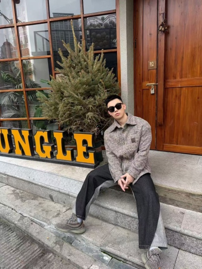 🔝LOEWE羅意威 皮章口袋羊毛混紡外套
採用精心配比的混紡面料，羊毛提供天然保暖與挺括廓形，馬海毛賦予面料細膩蓬松的絨毛感，少量錦綸的餵入則增強耐磨性與抗皺性，三者融合打造中克重的理想厚度，兼顧溫度與輕盈。通過“雙面磨毛”工藝處理，面料表面呈現豐盈的短絨毛肌理，觸感如羊絨般柔軟親膚，同時保留羊毛混紡的筋骨感。微型格紋圖案以沙米色為基底，交織灰、棕、藍三色紗線，通過色織工藝織就，微型格紋尺寸統一，細膩而不張揚，呈現低調的復古韻味。
面料經過3道磨毛工序，確保絨毛長度均勻（约0.3mm）