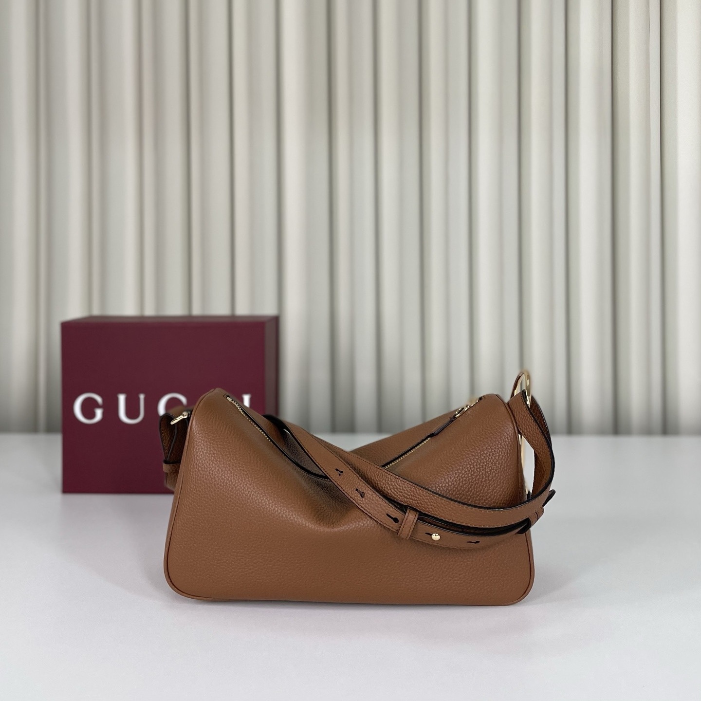 Gucci Half Horsebit系列中號肩背包，煥新呈現Gucci Half Horsebit系列，以現代風格煥新演繹品牌最具標誌性的元素之一。該系列巧妙融蘊休閒廓形與標誌性的半馬銜扣配件，這也是其名稱的由來。款號860787白皮，尺寸31.5X17X12