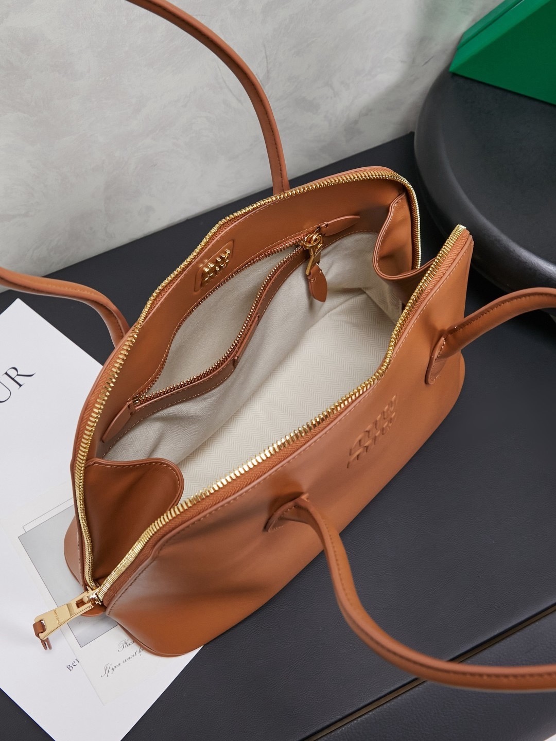 新品贝壳包，简便设计延续Miu慵懒美式老钱的风格，采用顶级进口小牛皮，质感高级柔软，两边弧度设计更具造型感，拉链拉开秒变大托特，长手柄设计实用性更强，可腋下可手提，造型简约潇洒随意，容量超大，上班通勤，逛街出游都是绝佳的选择，内里全新麻布里，配拉链式口袋