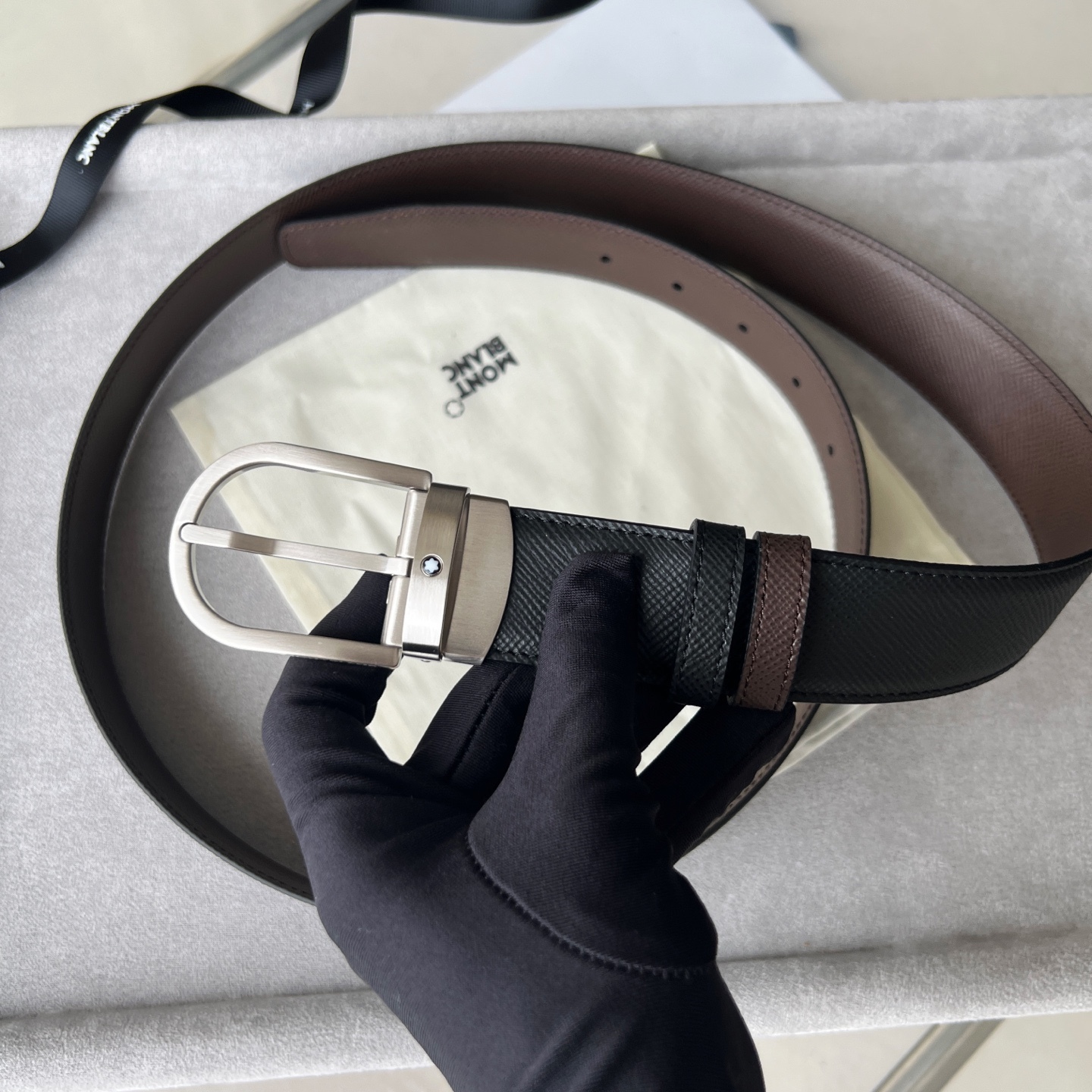 馬蹄形帶扣黑色/棕色雙面皮帶（35毫米）
馬蹄形閃亮鍍釕帶扣。可調節長度，3.5cm黑色和棕色雙面皮帶。打造經典靈動造型。
貨號 錶帶描述 黑色和棕色雙面牛皮皮帶 皮革圖案 金屬圓環上飾有萬寶龍六角白星 標識 搭扣裝置 易開啓裝置，可調節皮帶長度
搭扣形狀 馬蹄形主要顏色 黑色 | 棕色 搭扣類型 針扣式表扣