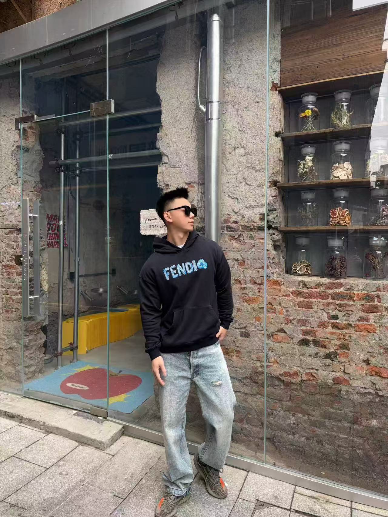 🔝FENDI芬迪FD 藍字母刺繡連帽衛衣
選用100%棉為基底編織而成的單面魚鱗布面料，正面為平滑的針織面，觸膚面通過針織機的浮線編織技術形成立體的毛圈，增加蓬松感， 同時觸感細膩。毛圈結構吸水量大且蒸發快，經過預縮處理之後，縮水率低於2%，確保成衣尺寸穩定。深藍色染整採用活性染料，色澤濃郁飽滿，多次洗滌不易褪色。
胸前“FENDI Flower”圖案採用日本田島繡花機精密刺繡，融合多色漸變與立體肌理，呈現獨特的水彩效果。字母與花朵圖案使用不同深淺的藍白漸變繡線，從淺藍到靛藍自然過渡，