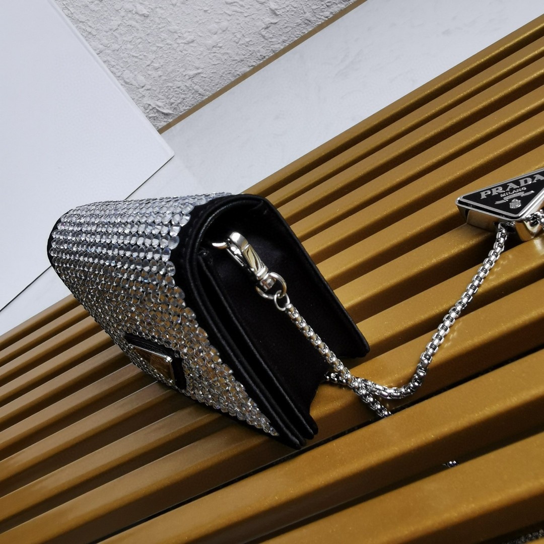 【 原單】🎉項鍊水晶小包🎉1MR024新色🎉🎉這款Duchesse面料卡片夾通體飾以仿水晶，於表面營造出光影格調和虹彩炫色，彰顯華美且不失功能性的設計。最愛是這條可拆卸可調節鐵璉肩帶，又可當腰包裝飾😍😍又可當搭配衣服項鍊裝飾，中間三角形標可調節活動，賦予單品多樣的佩戴方式。空間可裝口紅💄/耳機/鑰匙🚗....夜燈下bling bling,太美了。值得入手🎉🎉尺寸：長11.5cm*高8cm