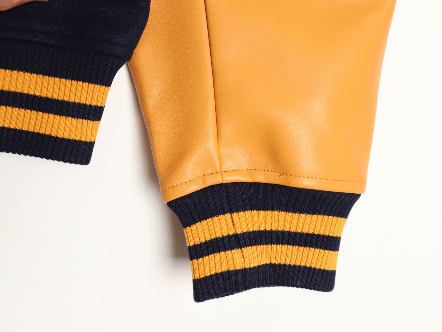 Louis Vuitton/路易威登 26ss 水鑽刺繡棒球服外套
材質拼接：衣身採用藏青色羊毛混紡面料，質感挺括耐磨；袖子為淺棕牛皮材質，柔軟細膩，經典拼皮設計還原美式棒球服復古感。

• 裝飾亮點：左胸位置有重工水鑽+金屬刺繡裝飾，鑲嵌多色寶石與閃鑽，綴有“L.V.M.”字母標識，華麗精緻，辨識度拉滿。

• 版型結構：立領+羅紋條紋領口/袖口/下擺，防風且修飾身形；正面按扣開合，兩側配有插袋，兼顧實用與美觀。
球帽點綴，休閒隨性又有街頭感。
N Size:S-XL