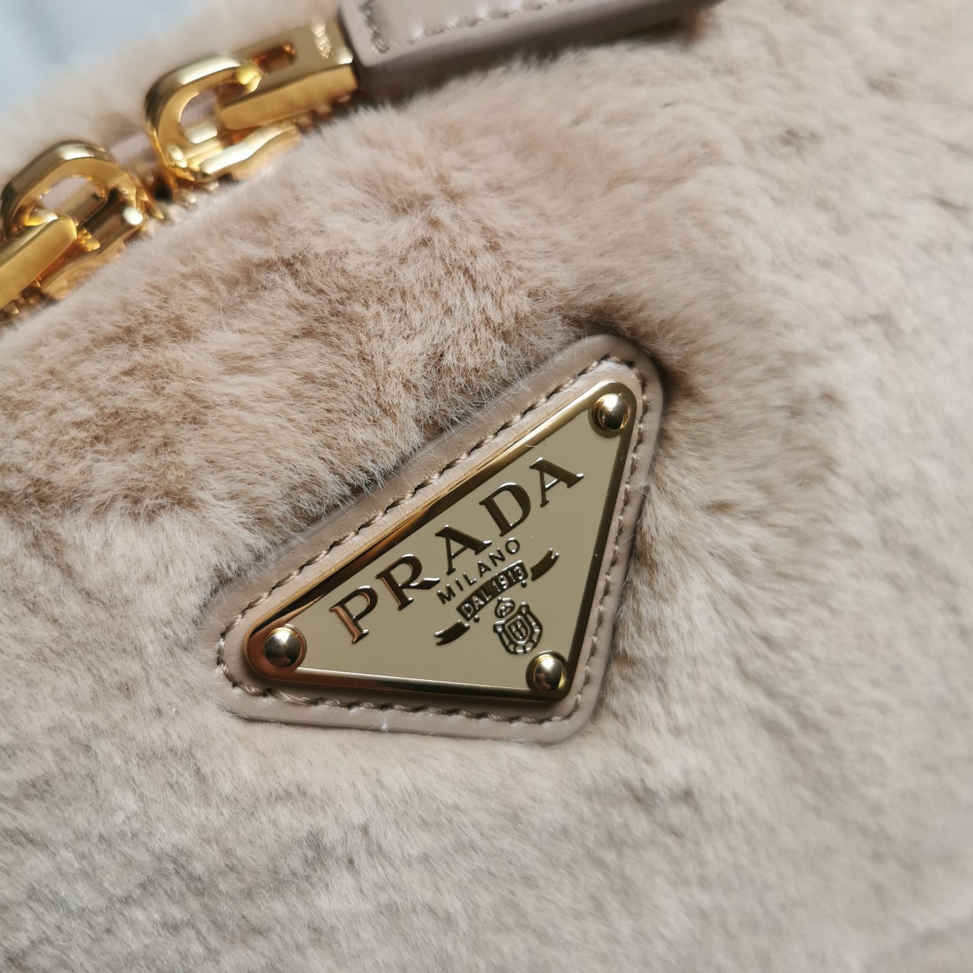 【 原單】🎉最新款迷你手袋🎉1BH208羊毛🎉🎉這款迷你手袋結構挺括，風格百搭，搭配柔軟的羊毛皮，彰顯冬日魅力。皮革細節與雙向拉鍊開合和金屬五金配件錦上添花，飾有塗琺瑯三角形金屬徽標。內配進口小羊皮，上身效果非常酷/時尚，冬天必備爆款🎉寶寶們，趕緊入手吧
尺寸：長19.5x高13x底6cm