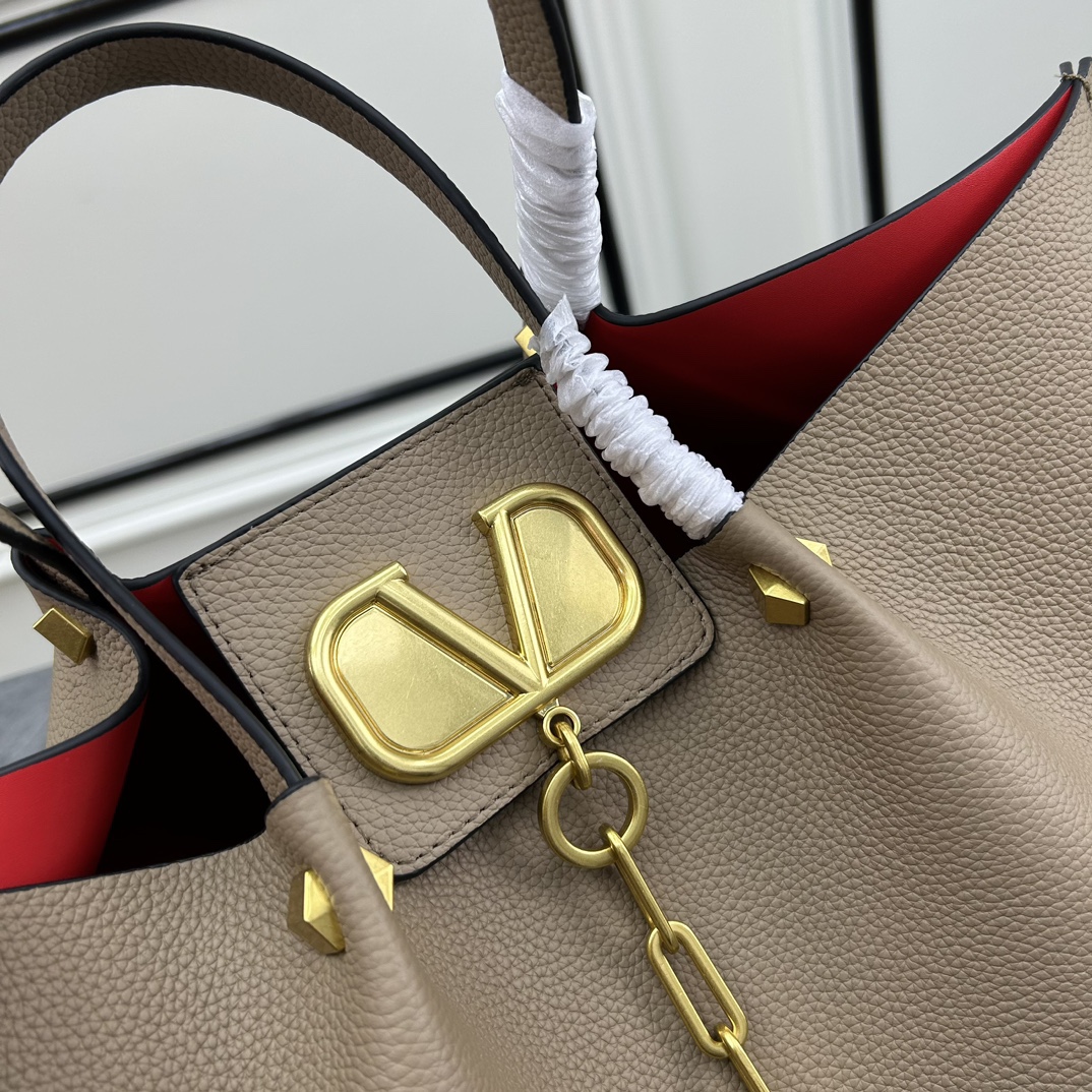 荔枝紋 Garavani VLOGO Escape 小牛皮小號購物袋，包袋兩側點綴紅色細節，金屬徽標飾件可用在包裝內部作為開合，亦可用在外部作為裝飾元素。
大號尺寸：41.*25*18cm