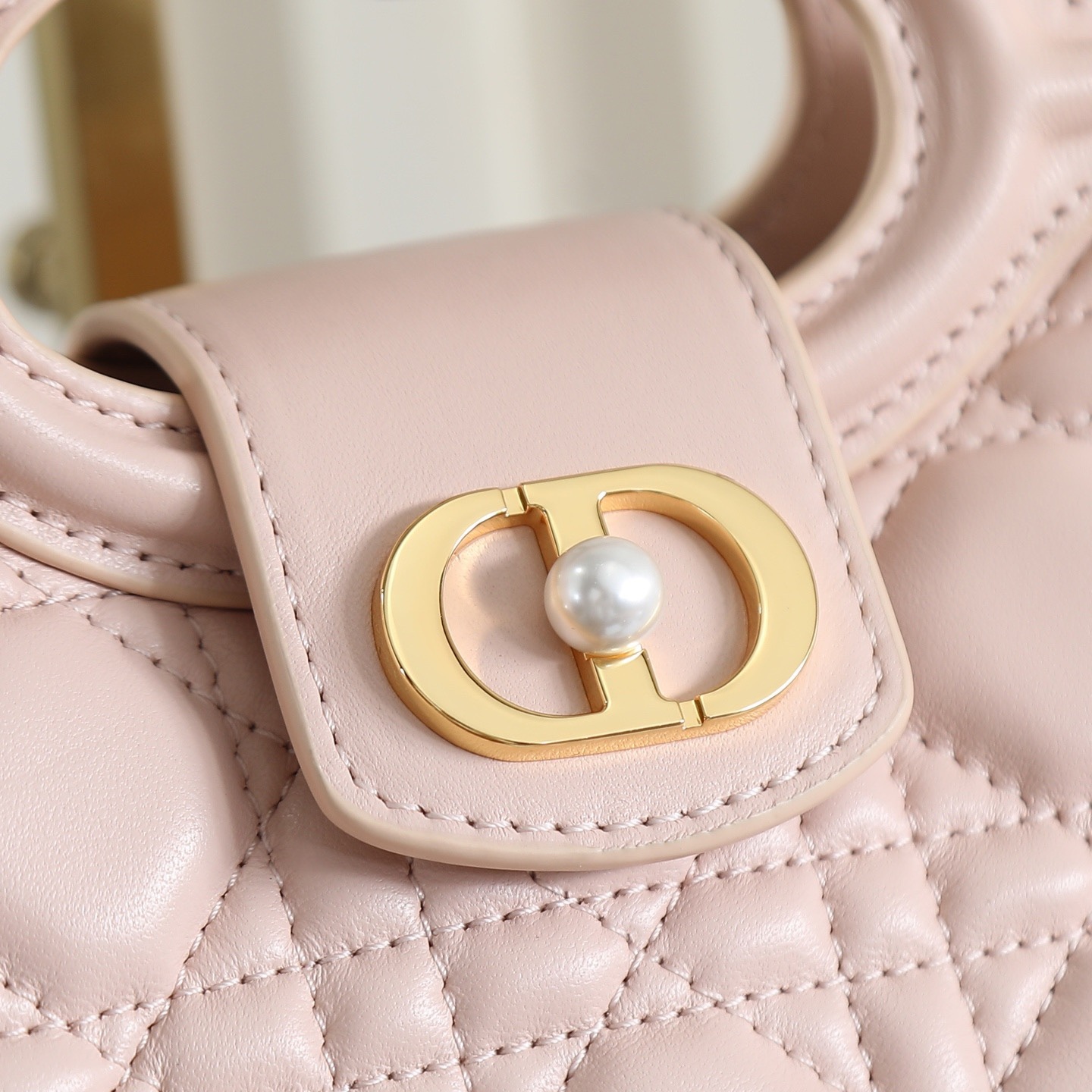 原廠級 粉色鏈條手袋
這款 Dior Jolie Top Handle 迷你鏈條手袋是二零二六早春成衣系列新品，呈現出優雅精緻的設計。採用黑色羊皮革精心製作，飾以藤格紋，翻蓋點綴以金色飾面金屬 CD 標誌和白色樹脂珠飾。內設一個隔層，可收納各種日常用品。搭配雙頂部手柄和可調節、可拆卸 CD 鏈條肩帶，肩帶由皮革帶和 CD 鏈環組成，飾以白色樹脂珠飾，可舒適手提、肩背或斜挎，可與日常或晚裝造型搭配。
