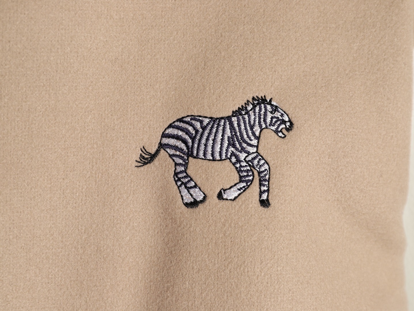 Louis Vuitton/路易威登 26ss 動物樂園刺繡棒球服外套
材質拼接：衣身採用淺卡其色羊毛混紡面料，柔軟且有挺括感；袖子為奶白色荔枝紋牛皮，質感細膩，淺色系搭配更顯清爽。

• 裝飾亮點：衣身滿印精緻動物刺繡（長頸鹿、斑馬、大象、黑豹等）與棕櫚樹圖案，左胸綴有“L.V.M.”字母標識，充滿童趣與度假感，辨識度極高。

• 版型結構：經典棒球服版型，羅紋條紋領口/袖口/下擺，防風收型；正面按扣開合，兩側配白色撞色插袋，兼顧實用性與設計感。
N SIZE:S-XL
