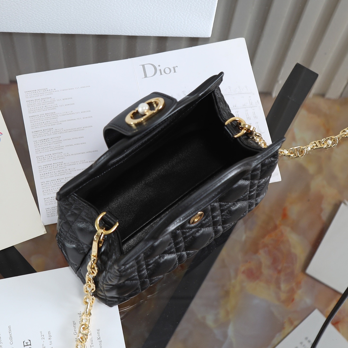 原廠級 黑色鏈條手袋
這款 Dior Jolie Top Handle 迷你鏈條手袋是二零二六早春成衣系列新品，呈現出優雅精緻的設計。採用黑色羊皮革精心製作，飾以藤格紋，翻蓋點綴以金色飾面金屬 CD 標誌和白色樹脂珠飾。內設一個隔層，可收納各種日常用品。搭配雙頂部手柄和可調節、可拆卸 CD 鏈條肩帶，肩帶由皮革帶和 CD 鏈環組成，飾以白色樹脂珠飾，可舒適手提、肩背或斜挎，可與日常或晚裝造型搭配。
