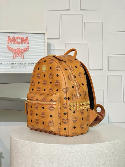 𝗠𝗖𝗠 𝗦𝘁𝗮𝗿𝗸 𝗩𝗶𝘀𝗲𝘁𝗼𝘀🆕升级
干邑色小号#铆钉双肩背包
全新升级最高版本
·Cp独家®️干邑色老花满印
这款豪华的双肩背包结构规整，采用经典Visetos材料制成，并饰以豪华的Nappa皮革饰边，其内部空间充裕，金字塔形的铆钉侧边使其前卫感十足。

型号：MMK6SVE37CO001
尺寸：33*13*26cm
肩带：可调节/不可拆卸
拉链：双向全闭合拉链
颜色：干邑色/Cognac 🟫