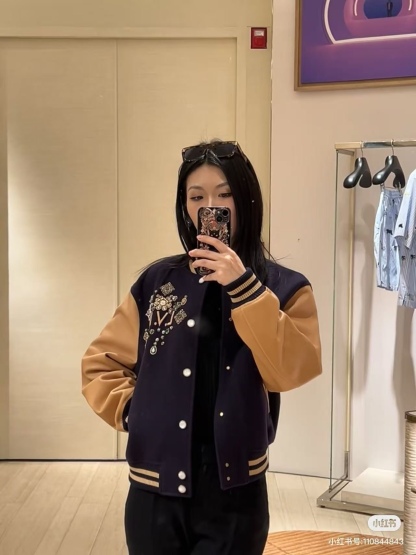 Louis Vuitton/路易威登 26ss 水鑽刺繡棒球服外套
材質拼接：衣身採用藏青色羊毛混紡面料，質感挺括耐磨；袖子為淺棕牛皮材質，柔軟細膩，經典拼皮設計還原美式棒球服復古感。

• 裝飾亮點：左胸位置有重工水鑽+金屬刺繡裝飾，鑲嵌多色寶石與閃鑽，綴有“L.V.M.”字母標識，華麗精緻，辨識度拉滿。

• 版型結構：立領+羅紋條紋領口/袖口/下擺，防風且修飾身形；正面按扣開合，兩側配有插袋，兼顧實用與美觀。
球帽點綴，休閒隨性又有街頭感。
N Size:S-XL
