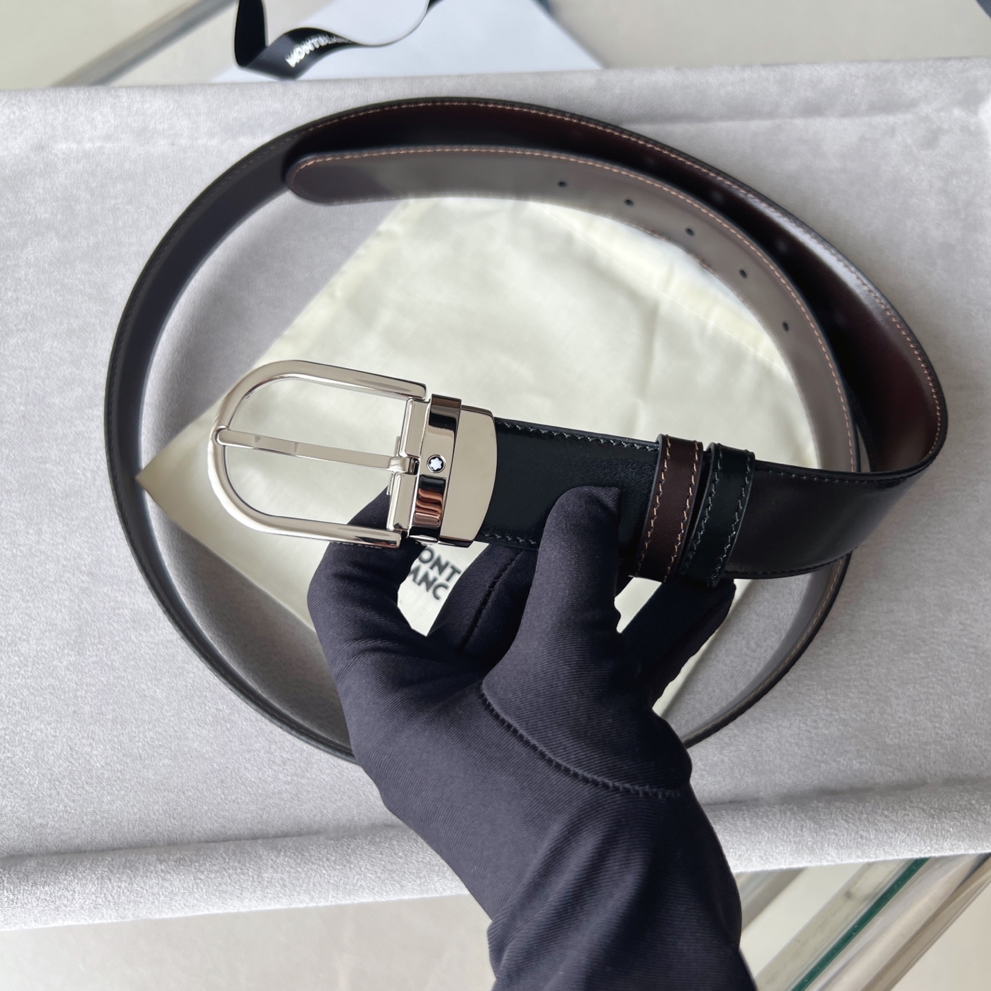 馬蹄形帶扣黑色/棕色雙面皮帶（35毫米）
馬蹄形閃亮鍍釕帶扣。可調節長度，3.5cm黑色和棕色雙面皮帶。打造經典靈動造型。
貨號 錶帶描述 黑色和棕色雙面牛皮皮帶 皮革圖案 金屬圓環上飾有萬寶龍六角白星 標識 搭扣裝置 易開啓裝置，可調節皮帶長度
搭扣形狀 馬蹄形主要顏色 黑色 | 棕色 搭扣類型 針扣式表扣