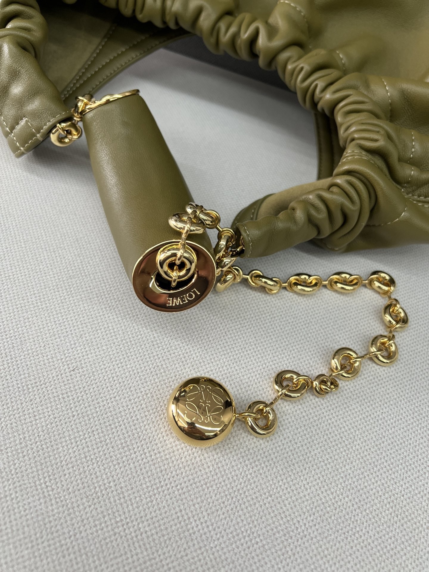 LO℮w℮🌟中號🆕納帕羊皮Squeeze手袋👜一款精緻而柔美的全新手袋，採用觸感柔軟的納帕皮革製成。這款順手藝是傳統工藝、創新研究和獨特設計的傑作，具備令人驚訝的輕盈褶皺包身、可調節甜甜圈鏈條和觸感柔軟的提手。此中號版本採用納帕羊皮革打造。*可肩背、斜挎或手提*可調節鏈條肩帶，搭配Anagram攜刻鵝卵石，附加額外鏈條，可進一步延長肩帶*磁扣開合*內部拉鍊口袋*無襯里*lo*ewe燙金或燙銀。
size：34*13.5*33CM
型號：652328 全鋼五金