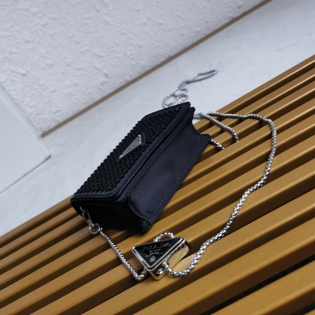 【 原單】🎉項鍊水晶小包🎉1MR024新色🎉🎉這款Duchesse面料卡片夾通體飾以仿水晶，於表面營造出光影格調和虹彩炫色，彰顯華美且不失功能性的設計。最愛是這條可拆卸可調節鐵璉肩帶，又可當腰包裝飾😍😍又可當搭配衣服項鍊裝飾，中間三角形標可調節活動，賦予單品多樣的佩戴方式。空間可裝口紅💄/耳機/鑰匙🚗....夜燈下bling bling,太美了。值得入手🎉🎉尺寸：長11.5cm*高8cm