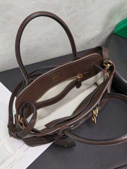 Aventure包袋展现出简约随性的魅力。重新诠释经典线条，这款柔软的Nappa变体展现出多功能和实用的态度，并通过精致独特的细节得到提升。aventure nappa皮革手袋灵感源自miu典藏设计，结构经过调整，变得更加轻便，焕发全新个性，饰以压花字母徽标，增添标志性元素，复古金色五金配件，亚麻混纺衬里，配拉链口袋和贴袋，长手腕适合用作手提或单肩