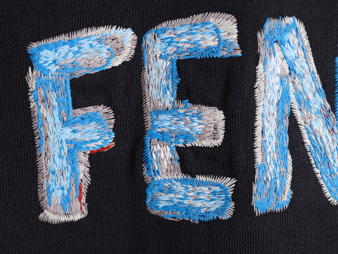 🔝FENDI芬迪FD 藍字母刺繡連帽衛衣
選用100%棉為基底編織而成的單面魚鱗布面料，正面為平滑的針織面，觸膚面通過針織機的浮線編織技術形成立體的毛圈，增加蓬松感， 同時觸感細膩。毛圈結構吸水量大且蒸發快，經過預縮處理之後，縮水率低於2%，確保成衣尺寸穩定。深藍色染整採用活性染料，色澤濃郁飽滿，多次洗滌不易褪色。
胸前“FENDI Flower”圖案採用日本田島繡花機精密刺繡，融合多色漸變與立體肌理，呈現獨特的水彩效果。字母與花朵圖案使用不同深淺的藍白漸變繡線，從淺藍到靛藍自然過渡，