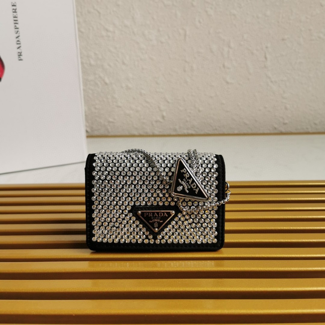 【 原單】🎉項鍊水晶小包🎉1MR024新色🎉🎉這款Duchesse面料卡片夾通體飾以仿水晶，於表面營造出光影格調和虹彩炫色，彰顯華美且不失功能性的設計。最愛是這條可拆卸可調節鐵璉肩帶，又可當腰包裝飾😍😍又可當搭配衣服項鍊裝飾，中間三角形標可調節活動，賦予單品多樣的佩戴方式。空間可裝口紅💄/耳機/鑰匙🚗....夜燈下bling bling,太美了。值得入手🎉🎉尺寸：長11.5cm*高8cm