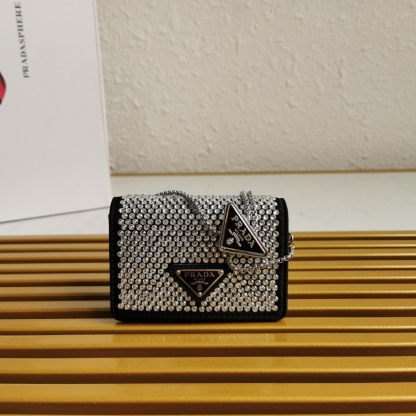 【 原單】🎉項鍊水晶小包🎉1MR024新色🎉🎉這款Duchesse面料卡片夾通體飾以仿水晶，於表面營造出光影格調和虹彩炫色，彰顯華美且不失功能性的設計。最愛是這條可拆卸可調節鐵璉肩帶，又可當腰包裝飾😍😍又可當搭配衣服項鍊裝飾，中間三角形標可調節活動，賦予單品多樣的佩戴方式。空間可裝口紅💄/耳機/鑰匙🚗....夜燈下bling bling,太美了。值得入手🎉🎉尺寸：長11.5cm*高8cm