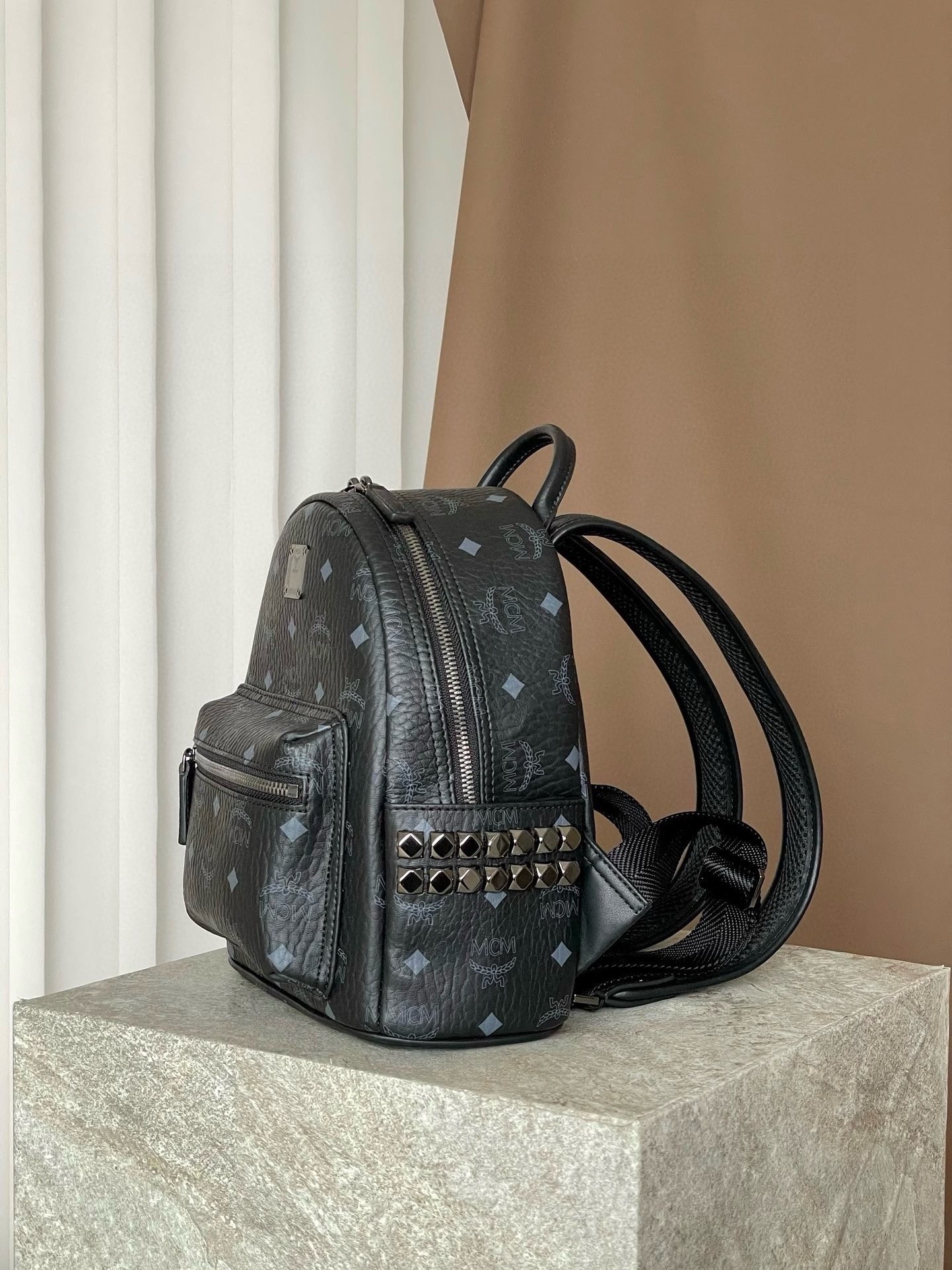 𝐌𝐂𝐌 𝐒𝐭𝐚𝐫𝐤 𝐕𝐢𝐬𝐞𝐭𝐨𝐬，𝐌𝐢𝐧𝐢 铆钉双肩背包黑色这款迷你 Stark 双肩背包是一款可以彰显独特风格的小配饰。MCM 经典款的缩小版本采用我们标志性的 Visetos 涂层帆布制成，配以奢华的人造皮革衬里和铆钉饰边