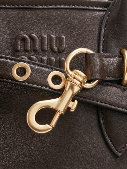 Aventure包袋展现出简约随性的魅力。重新诠释经典线条，这款柔软的Nappa变体展现出多功能和实用的态度，并通过精致独特的细节得到提升。aventure nappa皮革手袋灵感源自miu典藏设计，结构经过调整，变得更加轻便，焕发全新个性，饰以压花字母徽标，增添标志性元素，复古金色五金配件，亚麻混纺衬里，配拉链口袋和贴袋，长手腕适合用作手提或单肩