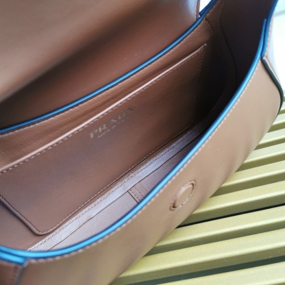 【 原單】P家🌹新款🎉Moon手袋液下包🎉1BD358到貨啦🎉🎉這款簡約Moon液下包為牛皮綻現摩登百搭的魅力。弧形包身設計，肩帶可調長短，磁扣開合翻蓋，便於隨心轉換造型。內配進口小羊皮，設有內袋，金屬配件更添亮麗格調，上身效果非常酷/時尚，又是一款永欠不過時爆款🎉寶寶們，趕緊入手吧🎉 尺寸：長25x高15x底5.5cm🎉🎉🎉🍊！