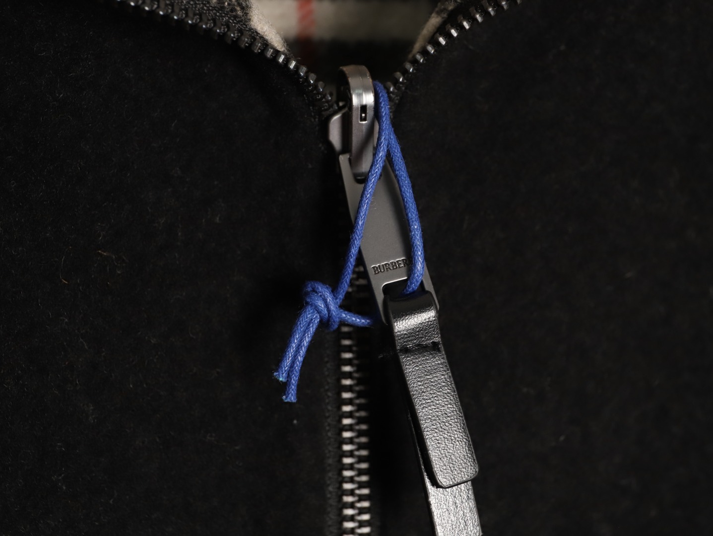 🔝BURBERRY巴寶莉BBR 雙面穿羊毛連帽外套
精選雙面羊毛斜紋面料，通過獨特的拉絨工藝處理，使表層呈現細膩豐盈的絨毛質感，觸感如雲朵般柔軟親膚，同時保留羊毛天然的保暖性與透氣性。一面以沈穩黑色演繹低調奢華，另一面則鋪滿標誌性的紅、黑、駝三色交織的經典圖案，既是品牌視覺符號，也為穿搭注入復古氣息。雙面可穿的設計，讓一件外套擁有兩種風格。
選用優質羊絨纖維進行精細紡紗，確保紗線的均勻性和強度。然後，通過先進的織造技術將紗線織成具有雙面效果的毛呢面料。
面料在裁剪前會經過預縮處理