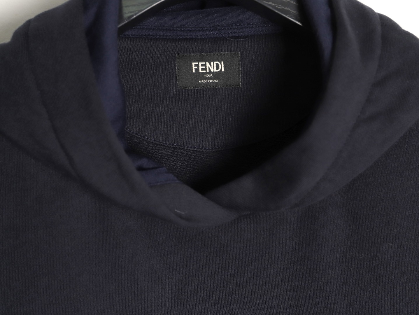 🔝FENDI芬迪FD 藍字母刺繡連帽衛衣
選用100%棉為基底編織而成的單面魚鱗布面料，正面為平滑的針織面，觸膚面通過針織機的浮線編織技術形成立體的毛圈，增加蓬松感， 同時觸感細膩。毛圈結構吸水量大且蒸發快，經過預縮處理之後，縮水率低於2%，確保成衣尺寸穩定。深藍色染整採用活性染料，色澤濃郁飽滿，多次洗滌不易褪色。
胸前“FENDI Flower”圖案採用日本田島繡花機精密刺繡，融合多色漸變與立體肌理，呈現獨特的水彩效果。字母與花朵圖案使用不同深淺的藍白漸變繡線，從淺藍到靛藍自然過渡，