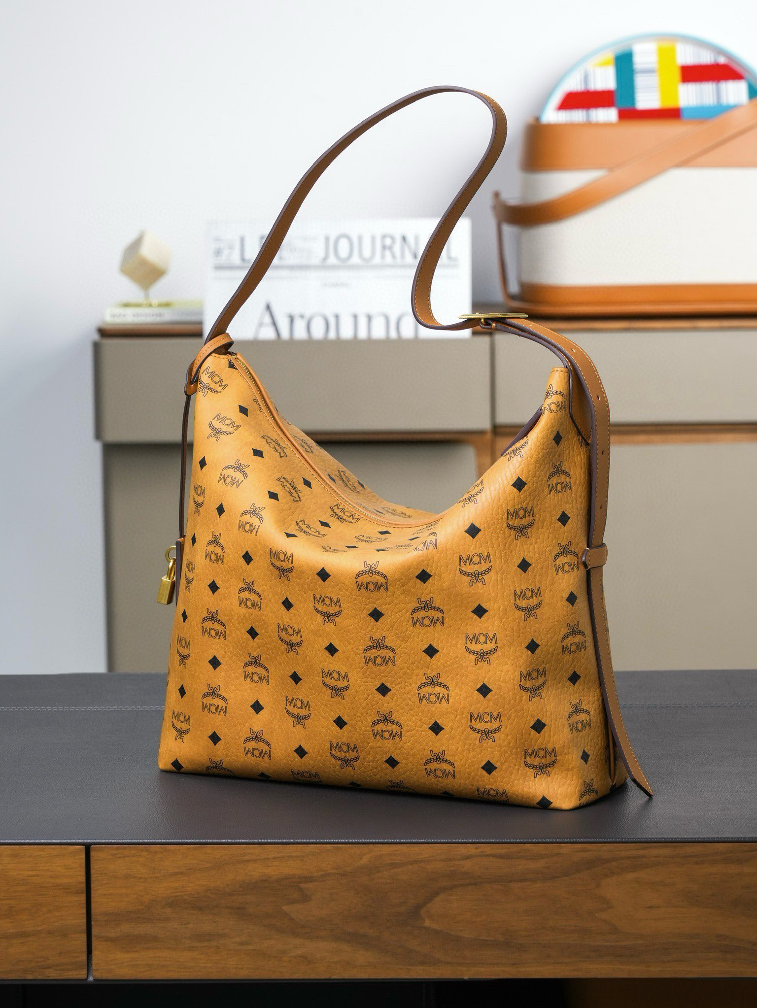 ®新品上市®官網同步
𝙈𝘾𝙈 𝘼𝙧𝙚𝙣 𝙃𝙤𝙗𝙤🆕新款
乾邑色大號#肩背包

·CP獨家出品｜乾邑色
這款Visetos Hobo包採用可調節皮革肩帶設計，並飾有帶掛鎖的皮革吊牌。
這款單品對經典的休閒款式進行了現代風的全新演繹，在柔軟與挺闊之間取得了理想的平衡。這款大號Aren Hobo肩背包採用了傳統MCM行李箱的設計元素，包括一個可拆卸皮革吊牌及雕花Logo掛鎖，達到錦上添花的效果。
