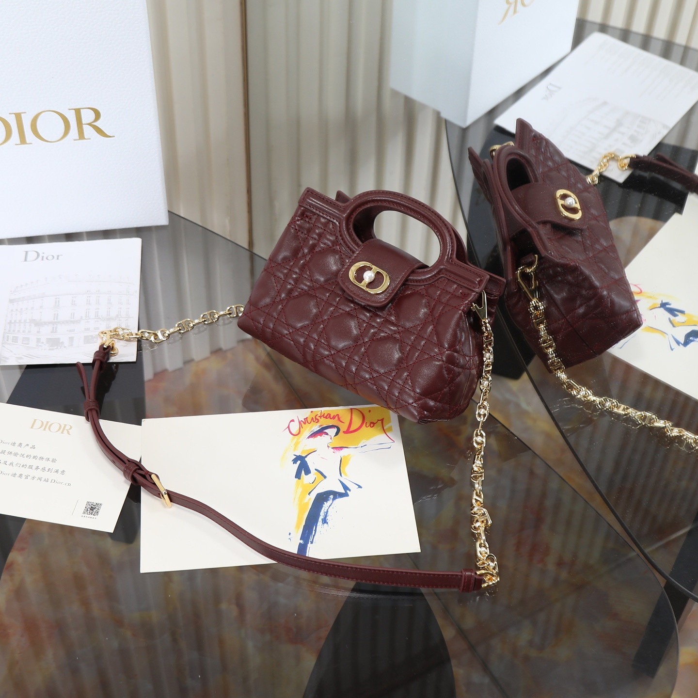 原廠級 酒紅色鏈條手袋
這款 Dior Jolie Top Handle 迷你鏈條手袋是二零二六早春成衣系列新品，呈現出優雅精緻的設計。採用黑色羊皮革精心製作，飾以藤格紋，翻蓋點綴以金色飾面金屬 CD 標誌和白色樹脂珠飾。內設一個隔層，可收納各種日常用品。搭配雙頂部手柄和可調節、可拆卸 CD 鏈條肩帶，肩帶由皮革帶和 CD 鏈環組成，飾以白色樹脂珠飾，可舒適手提、肩背或斜挎，可與日常或晚裝造型搭配。
