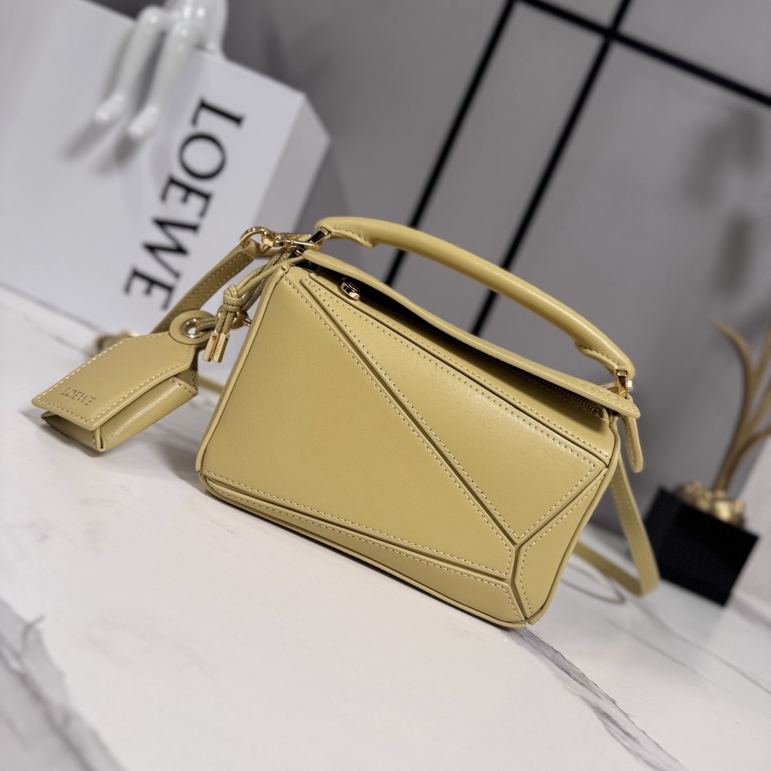 LO℮w℮🌟新款 迷你納帕羊皮革 Featherlight Puzzle 手袋 以別具一格的幾何線條勾勒長方體造型。柔軟輕盈的納帕皮革為手袋注入隨性慵懶的風格。可肩背、斜挎或手提
可拆卸可調節肩帶，飾有旋轉卡扣*拉鍊開合，鉸接式拉鍊頭 一個外部拉鍊後袋，一個內部插袋*可拆卸 LOE**WE 燙金或燙銀標籤，飾有隱秘口袋和氣球骰子*長方形金屬腳釘 納帕羊皮革襯里 Anagram 壓紋、飾牌內部鐫刻 LOE**WE.
型號：062511
size:17.5*7.5*12.5CM（配全套包裝）