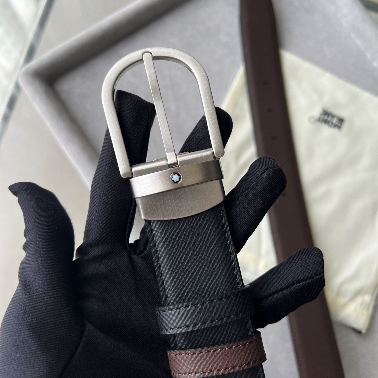 馬蹄形帶扣黑色/棕色雙面皮帶（35毫米）
馬蹄形閃亮鍍釕帶扣。可調節長度，3.5cm黑色和棕色雙面皮帶。打造經典靈動造型。
貨號 錶帶描述 黑色和棕色雙面牛皮皮帶 皮革圖案 金屬圓環上飾有萬寶龍六角白星 標識 搭扣裝置 易開啓裝置，可調節皮帶長度
搭扣形狀 馬蹄形主要顏色 黑色 | 棕色 搭扣類型 針扣式表扣