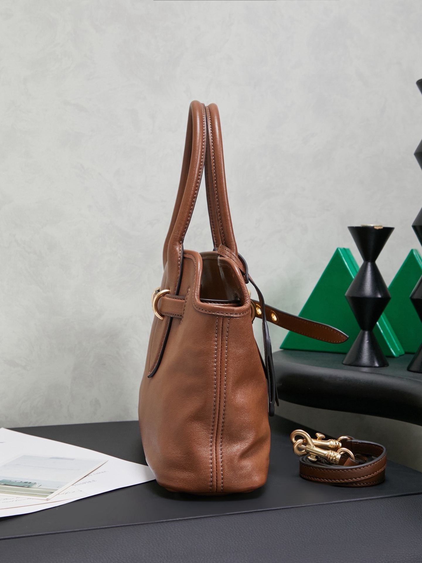 Aventure包袋展现出简约随性的魅力。重新诠释经典线条，这款柔软的Nappa变体展现出多功能和实用的态度，并通过精致独特的细节得到提升。aventure nappa皮革手袋灵感源自miu典藏设计，结构经过调整，变得更加轻便，焕发全新个性，饰以压花字母徽标，增添标志性元素，复古金色五金配件，亚麻混纺衬里，配拉链口袋和贴袋，长手腕适合用作手提或单肩
